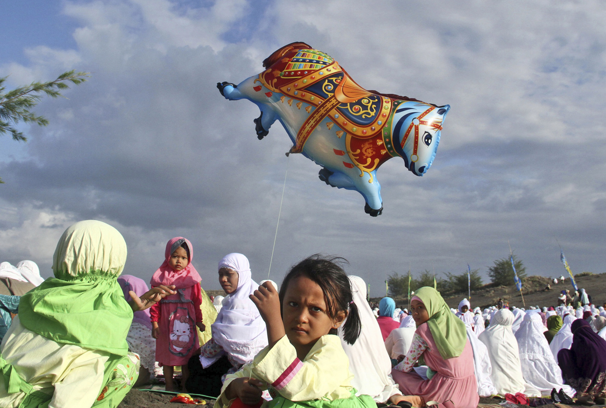 An Indonesian girl holds a balloon during Eid al-Fitr prayer