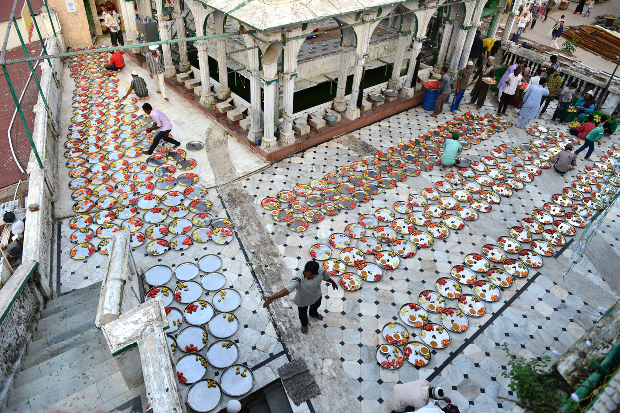 Indian Muslims lay out food for Iftar, the breaking of fast during Ramadan at the Alif Ni Masjid in Ahmedabad on July 27