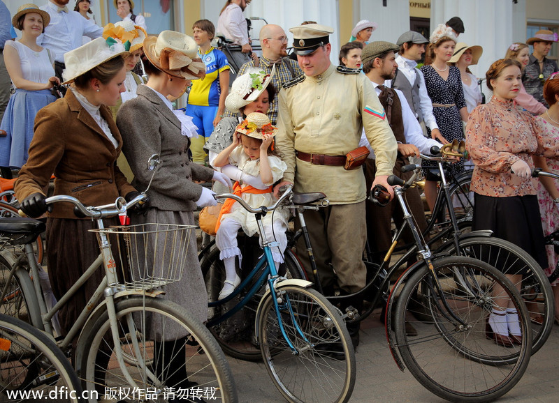 Dressed in vintage clothes, participants in St. Petersburg, Russia, ride on vintage bicycles during this year's Five Bridge Tweed Run ۴